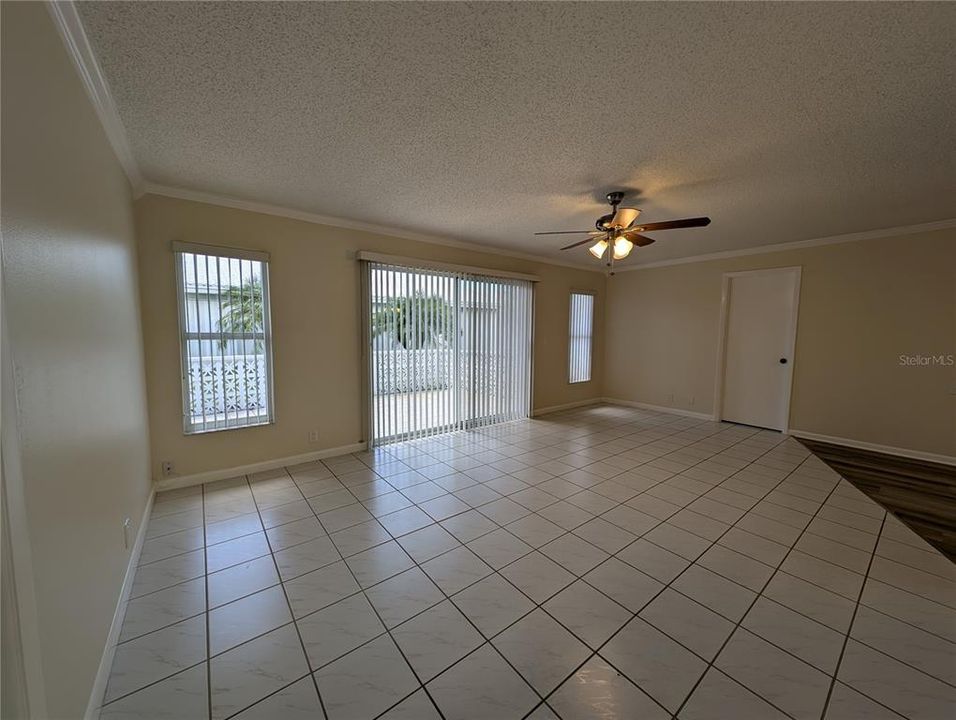 Florida room features tile flooring, ceiling fan, sliding door to back patio, access to master bath on right and 3rd bedroom on left side.