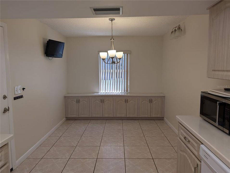 View of extra cabinetry in eat in area of kitchen.  Garage access door on left.