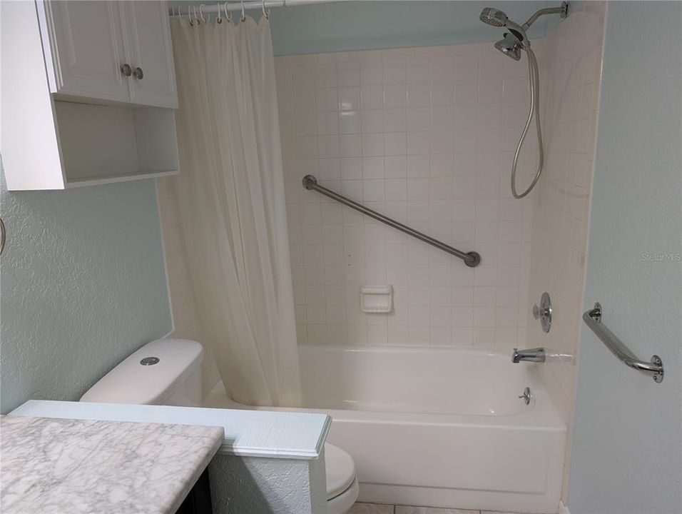 View of guest bathtub with safety grab bars.