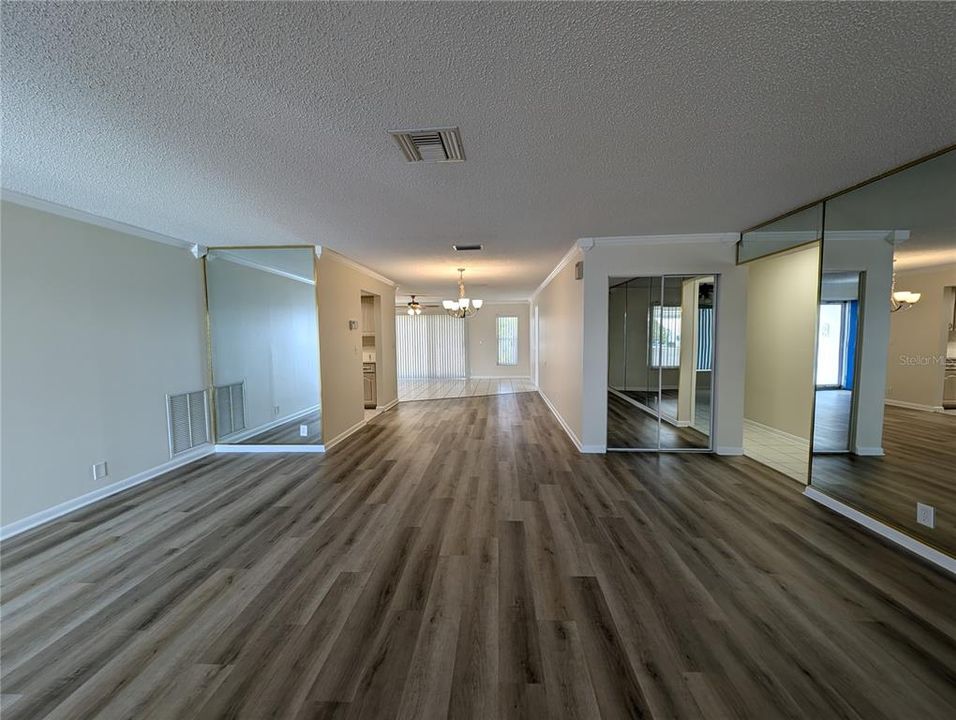 View from front entry thru dining room into Florida room.  Mirror linen/coat closet at hallway entry to two bedrooms and baths on right.  Kitchen is left of dining area.