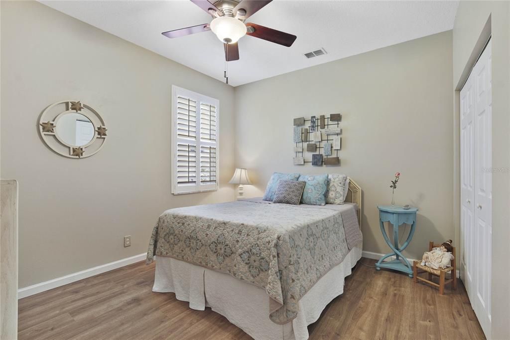 11' x 12'6" Bedroom #3 w/ luxury vinyl flooring, Plantation style shutter & a ceiling fan