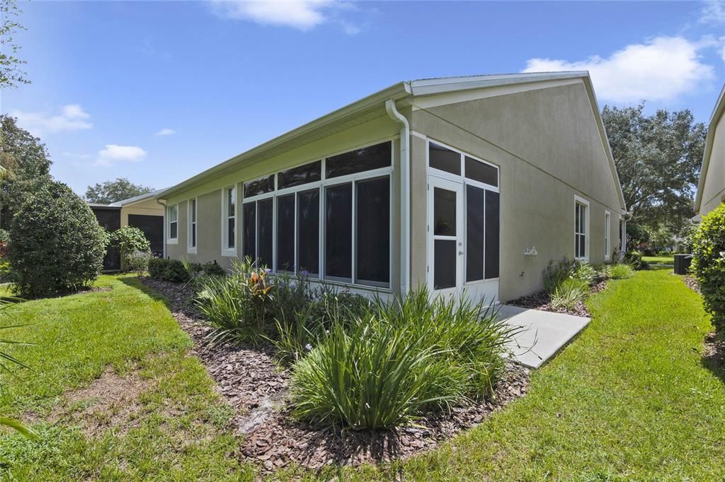 View of the enclosed Lanai & gutter downspout along rear of home