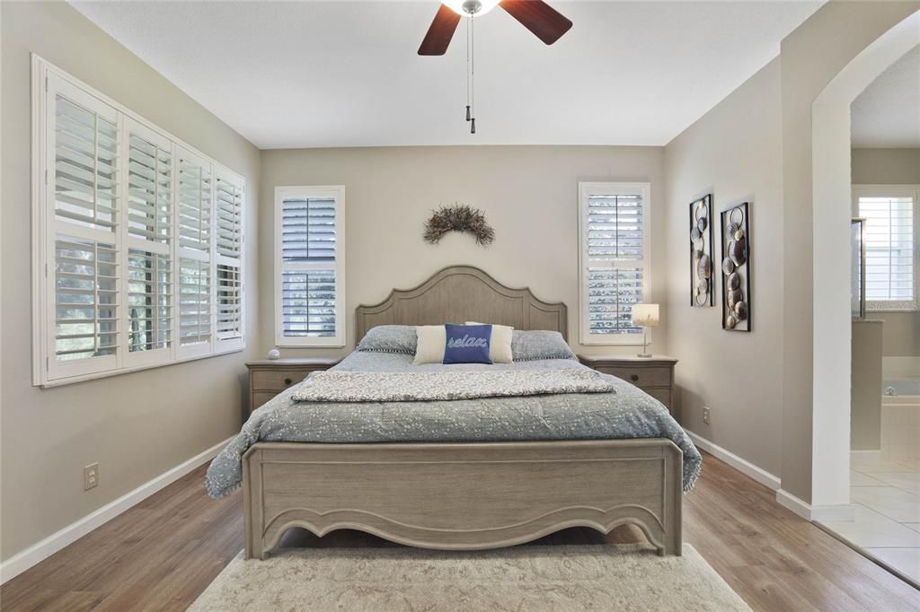 Primary Bedroom w/ several windows for natural light & a conservation area view