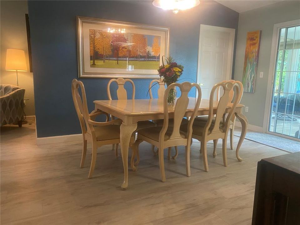 Dining area features a beautiful designer light fixture for ample lighting.