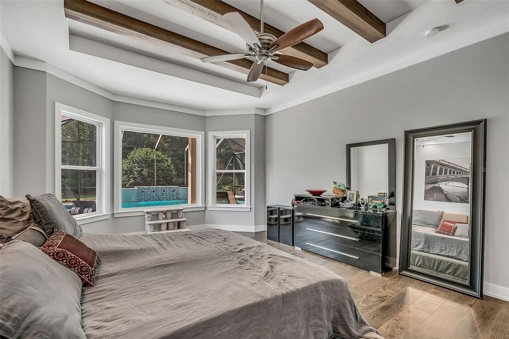 Owners suite with wood beams and bay window