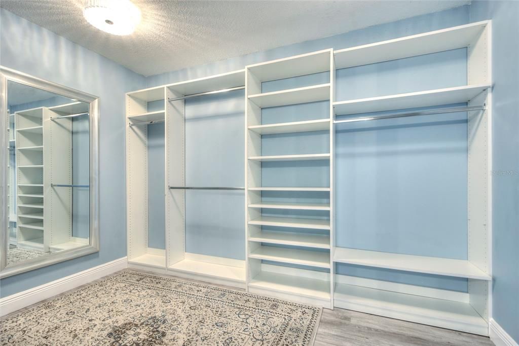 WALK IN CLOSET WITH LARGE MIRROR BUILT IN SHELVING