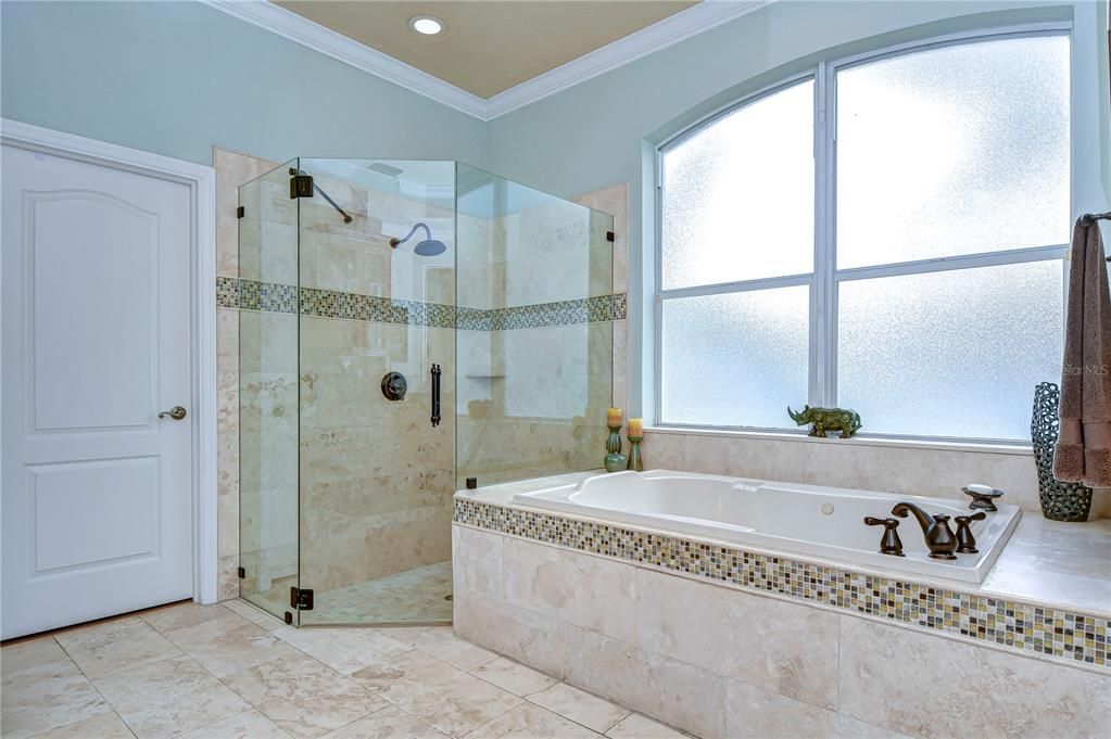 Seamless glass shower, travertine tile, and jetted tub!