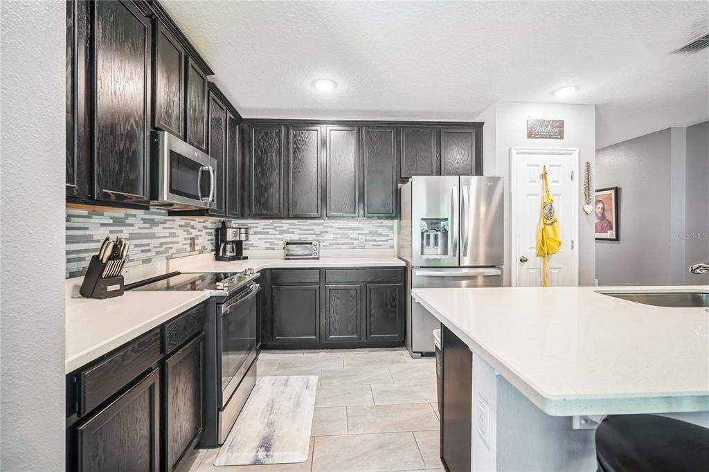 open floor plan. the kitchen open to the dining, living and porch area with the garden and wooded area.