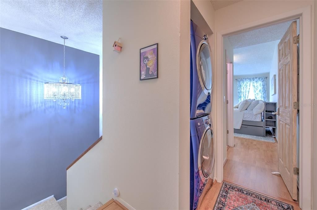 View of Chandler in the stairwell and stackable washer and dryer