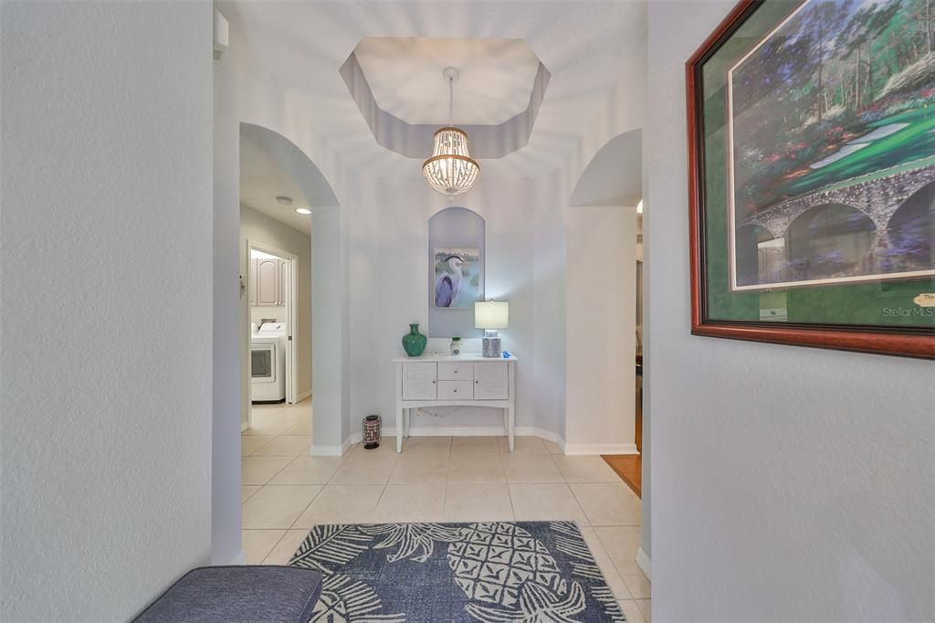 Walk into an inviting foyer entrance which has elegant neutral tones, contemporary lighting, tray ceilings and architectural niches.