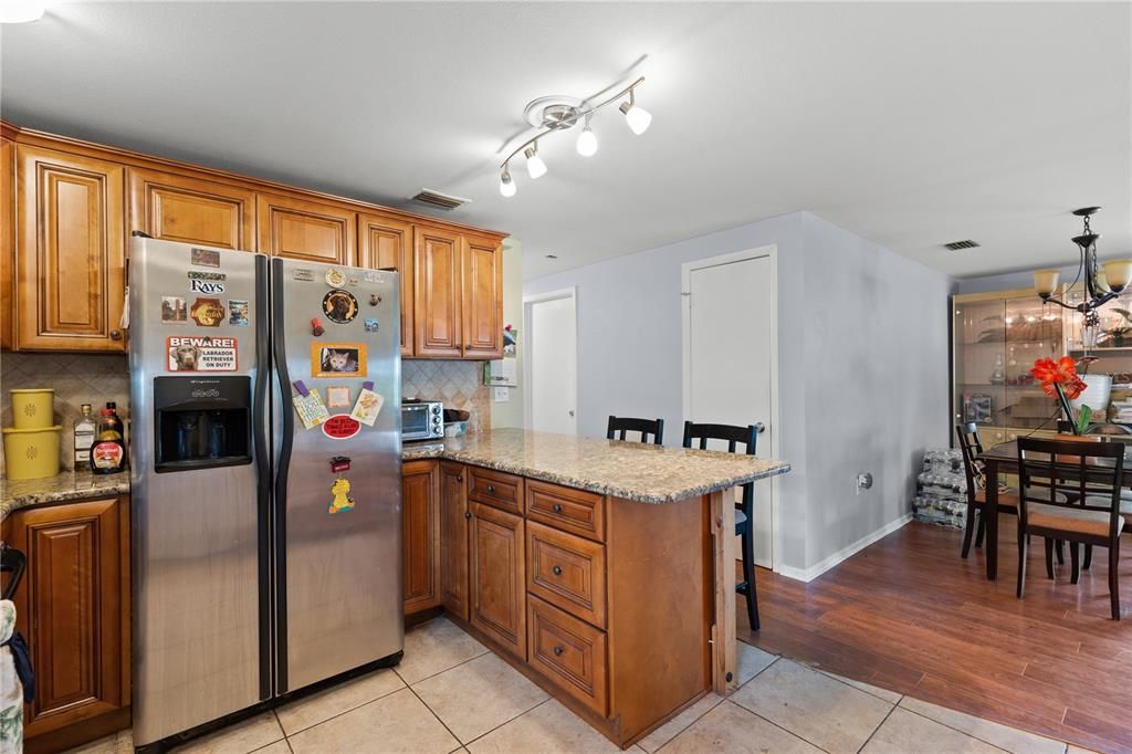 Renovated kitchen featuring stainless steel appliances, ample wood cabinetry, and breakfast bar.