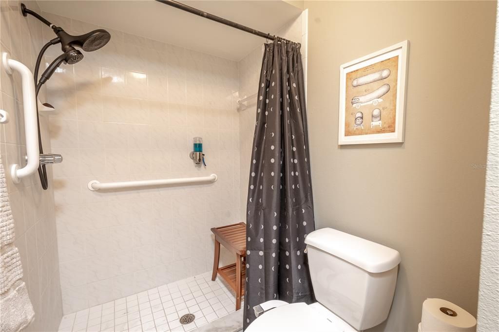 The primary ensuite features a tiled, walk-in shower with grab bars