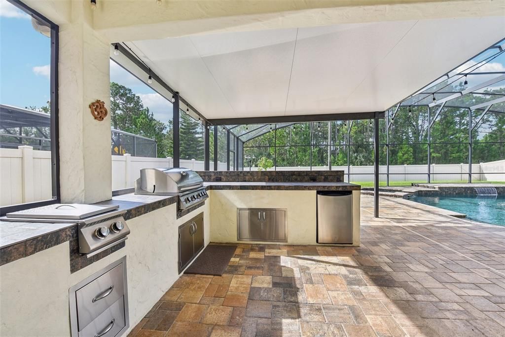 OUTDOOR KITCHEN with Built in Grill, Refrigerator, Cook Top, Sink, a Bar and LOTS OF COUNTER SPACE