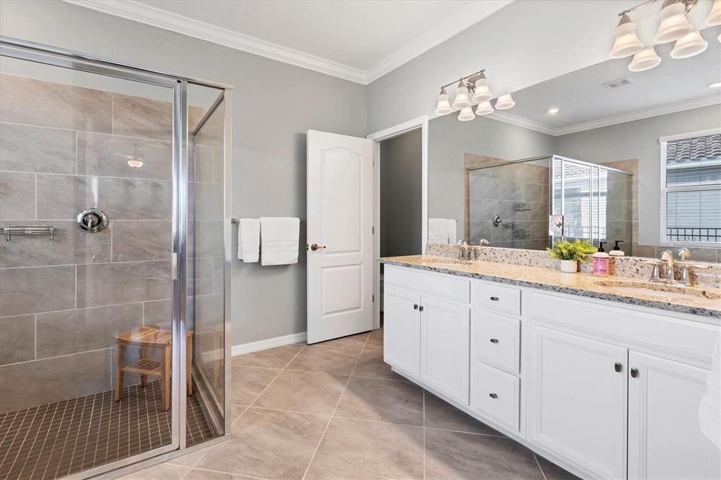 Primary Bathroom with dual sinks and separate water closet with storage