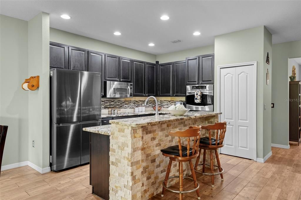 Gourmet kitchen with stainless steel appliances, including high end refrigerator, glass cooktop and double ovens