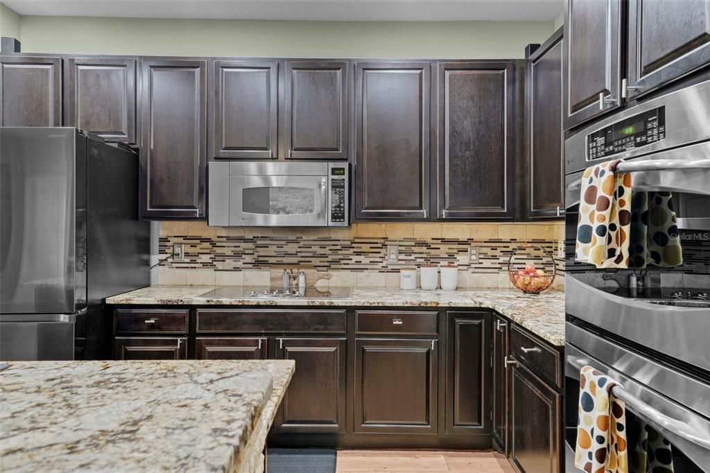 Gourmet kitchen with stainless steel appliances, including high end refrigerator, glass cooktop and double ovens