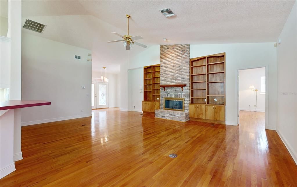 FORMAL LIVING ROOM WITH BRICK ACCENT FROM FLOOR TO CEILING.