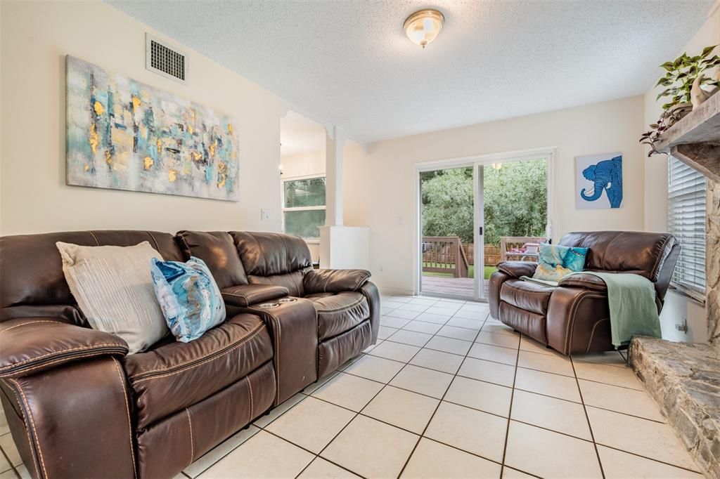 Family Room with Fireplace, tile flooring and new slider doors to the deck and backyard.