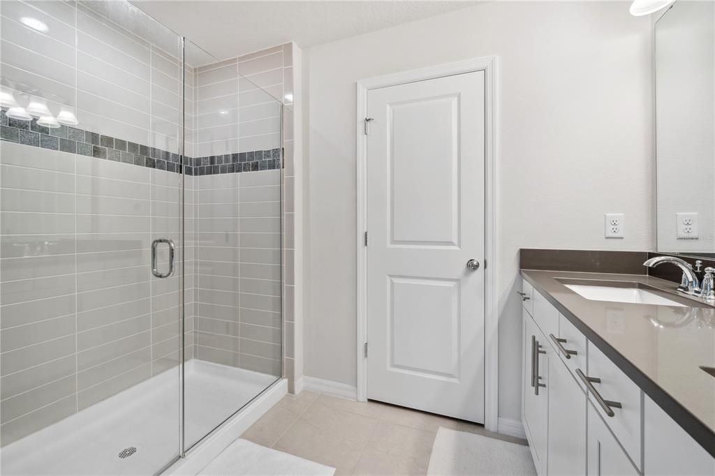 Primary bathroom includes a large walk in shower and dual sink vanity