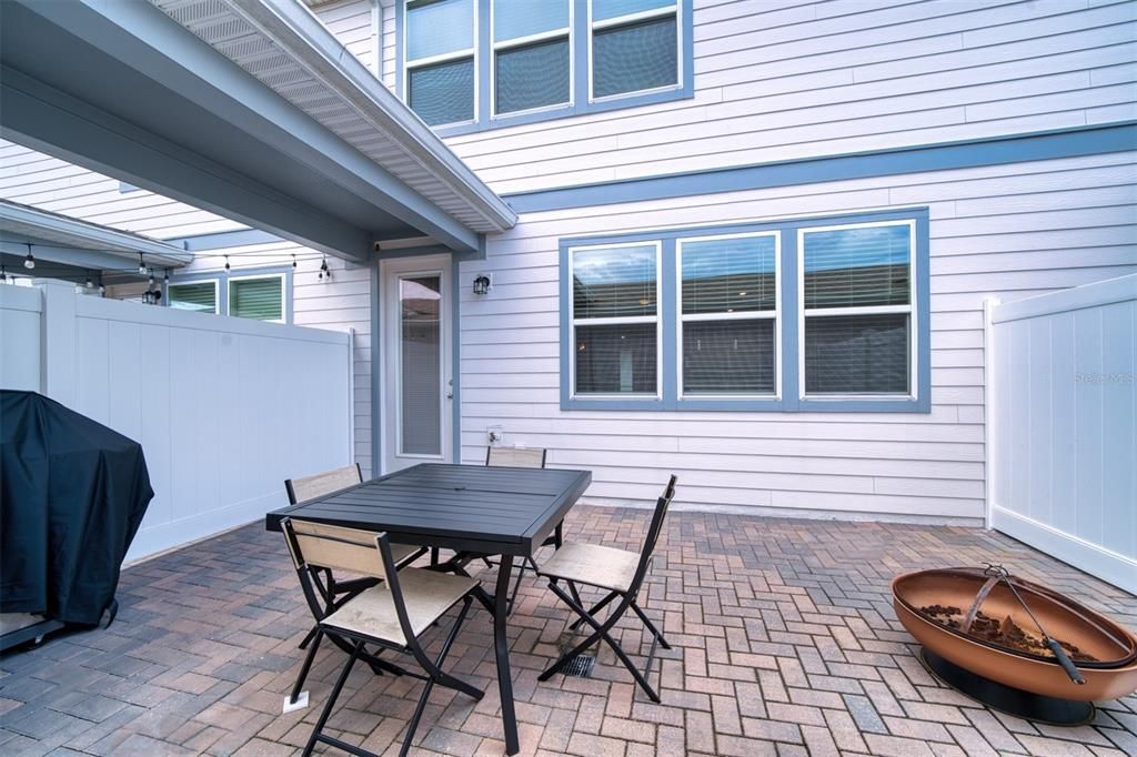 Paved courtyard with covered walkway connecting the home and the garabe