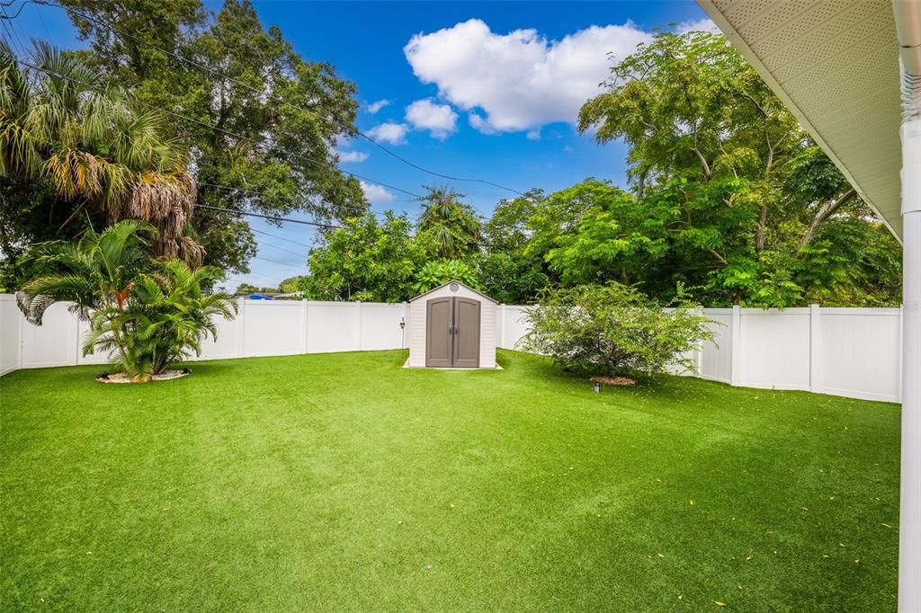 Pet-friendly turf, vinyl privacy fence, and storage shed make for a well-equipped rear lawn.