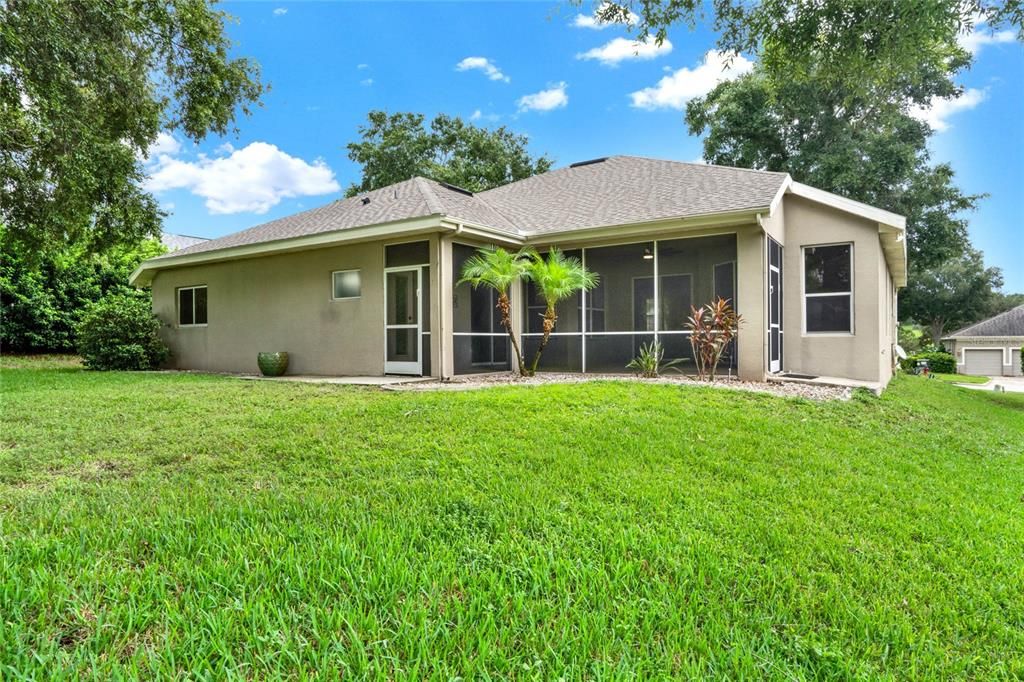 The lanai features two doors providing access to the serene and spacious backyard.