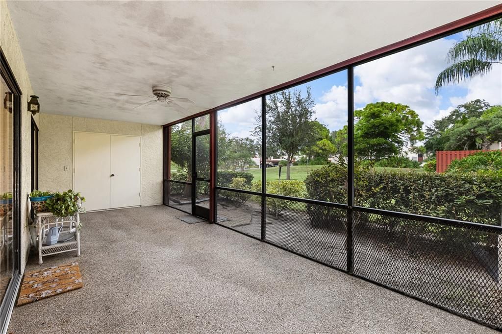 Screened-in lanai with views of the community's common area.