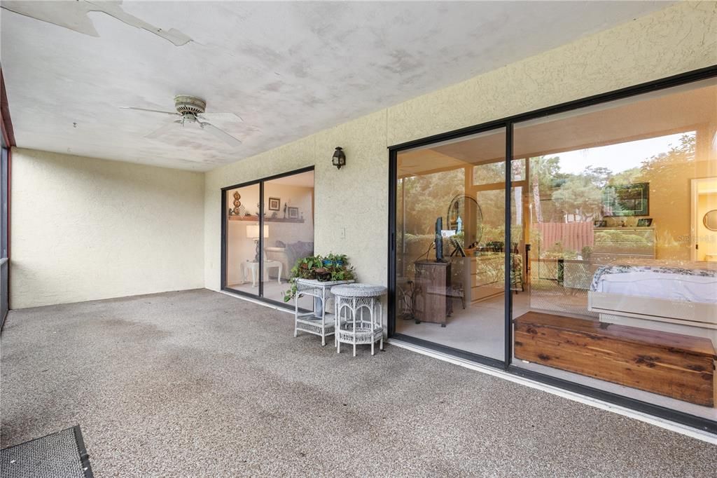 Screened-in lanai with views of the community's common area.