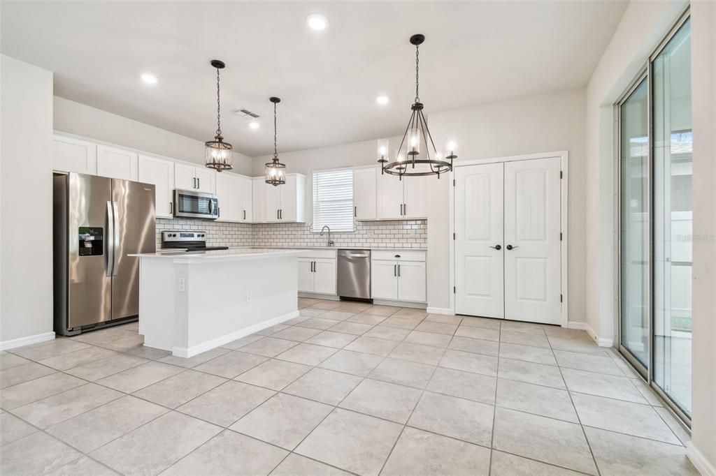 Fully equiped kitchen: Stainless Steel appliances and Quartz counters, trending fixtures, closet pantry and slider to screened lanai!