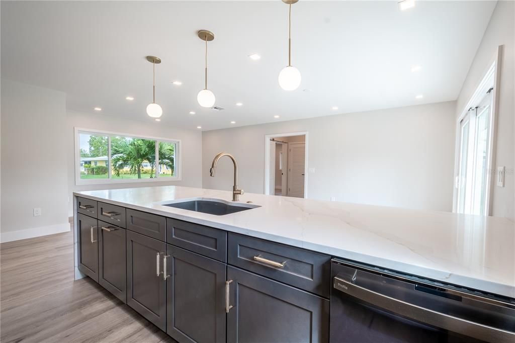 Three stylish pendent lights compliment the kitchen island and breakfast bar.