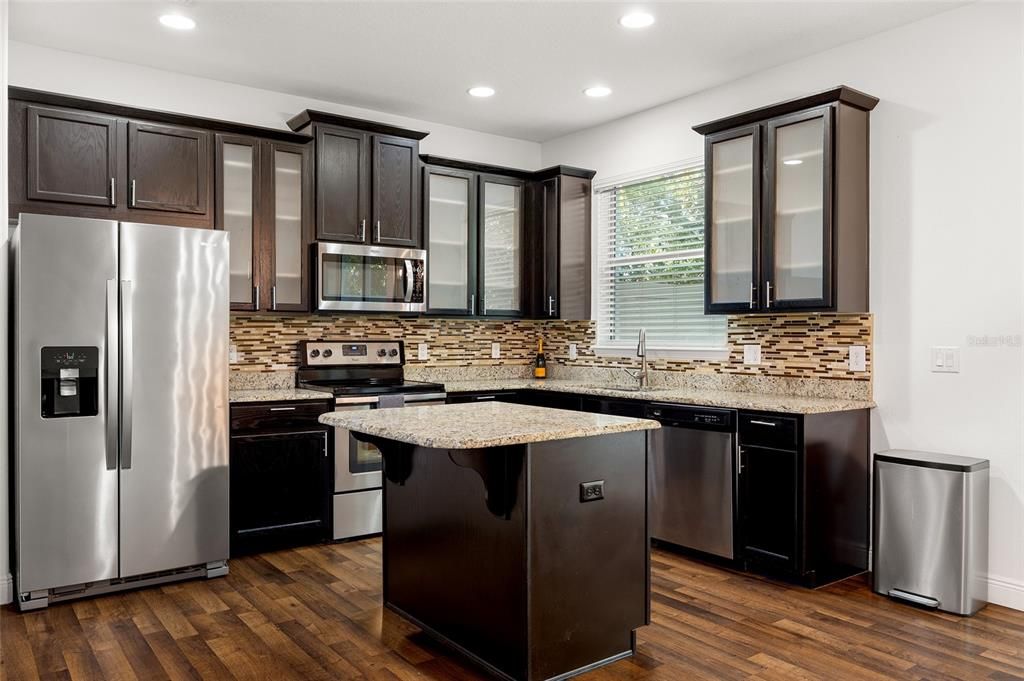 Kitchen has stainless steel appliances and an island.