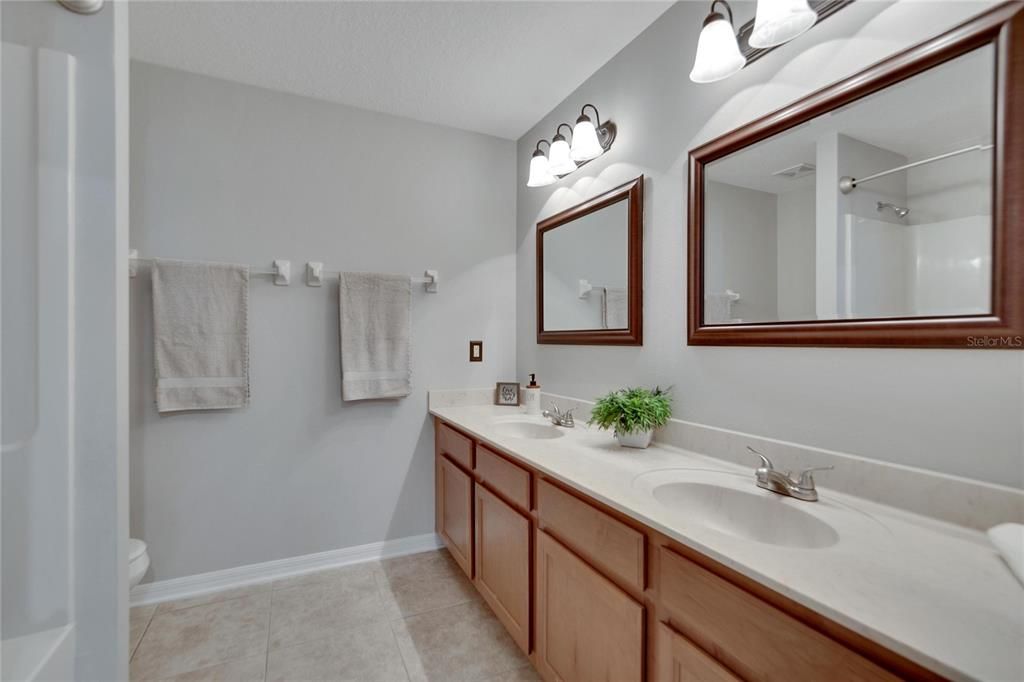 Large bath with dual sinks and updated mirrors and lighting.