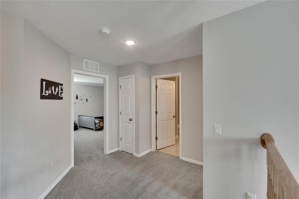 Hallway between bedrooms two and three with a full bathroom.