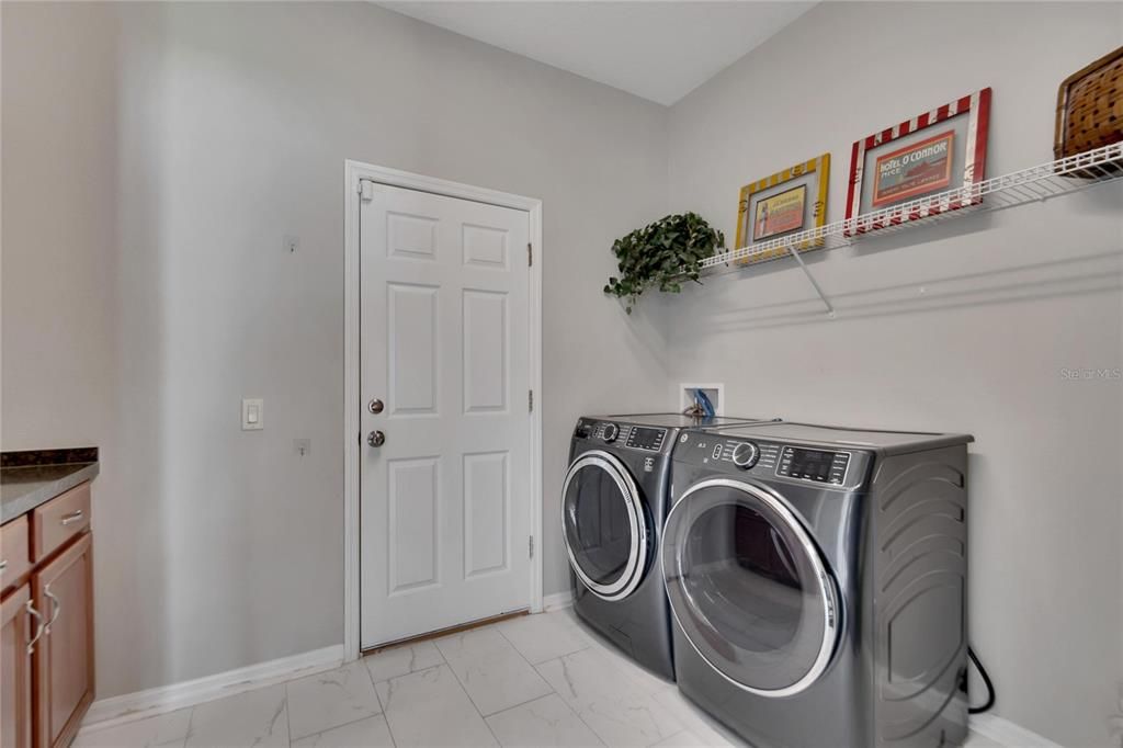 Large indoor laundry room with a built in cabinet wtih counter.