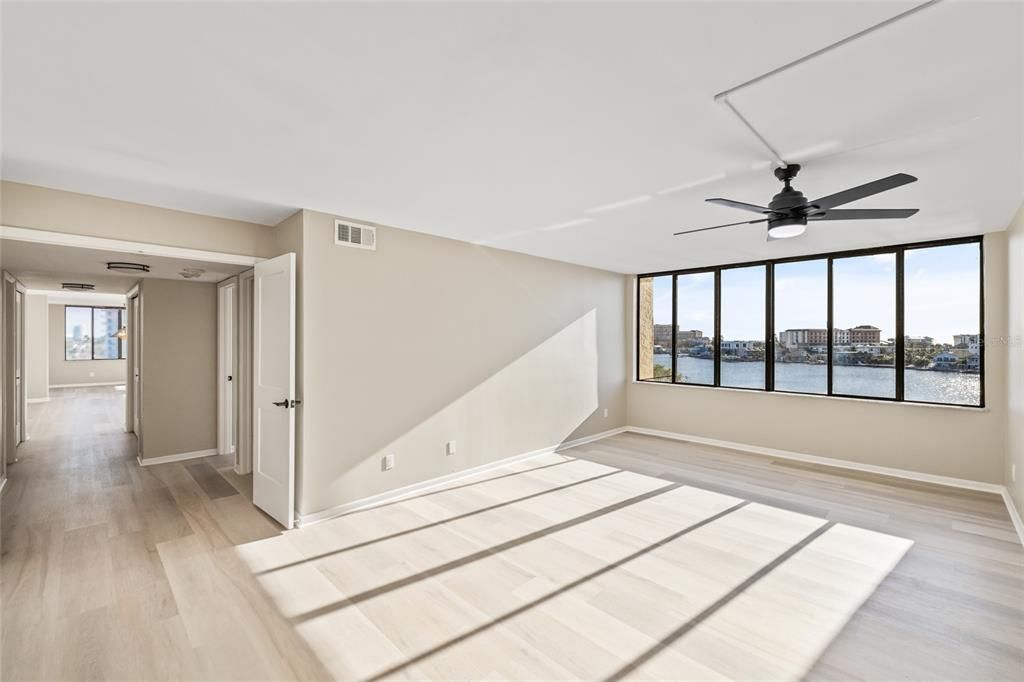 Primary bedroom with double doors and wall to wall windows and water views.