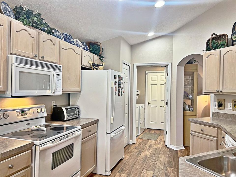 Kitchen with view of laundry, laminate flooring