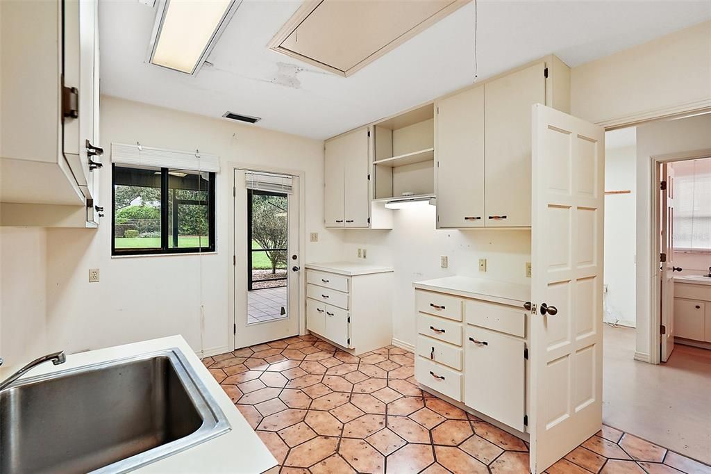 Laundry/Utility area opens to the rear patio, a workshop and half bath.