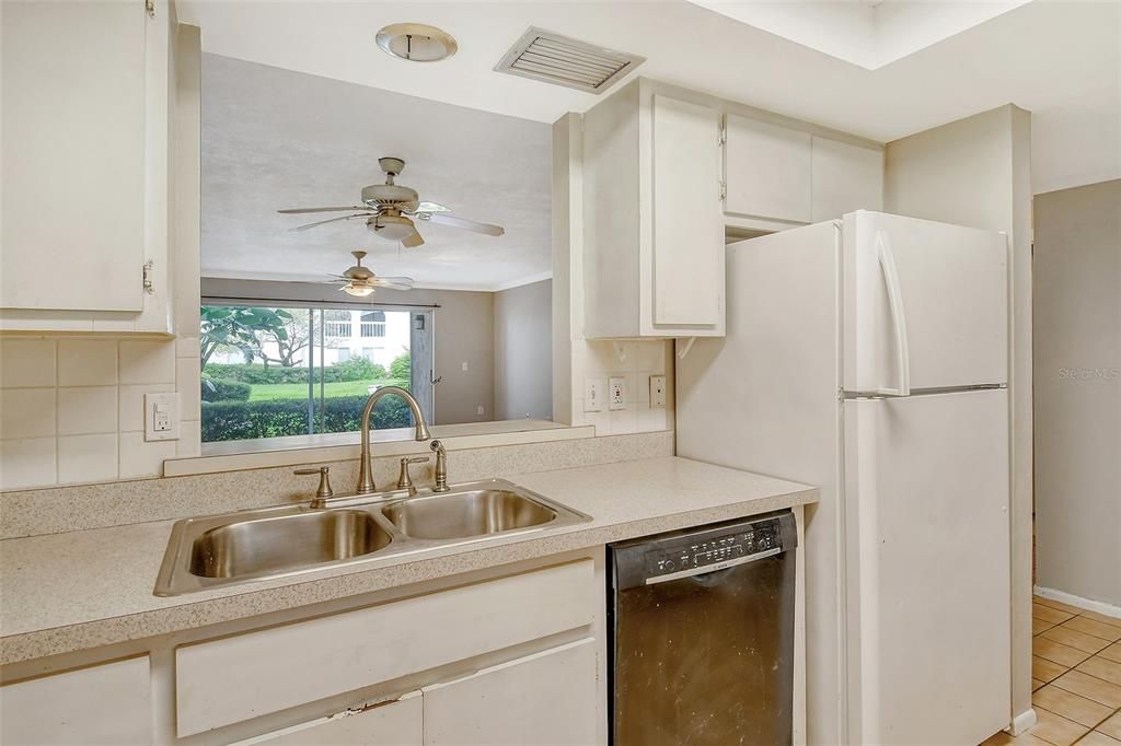 Kitchen with cut thru window, looking into dining and living room