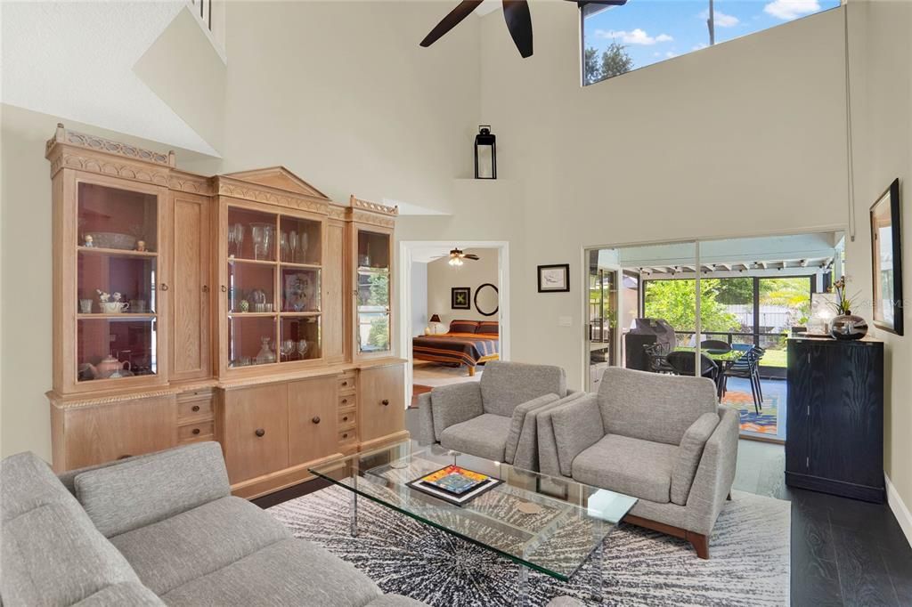 Living room with Cathedral Ceilings and slider to screened patio and pool