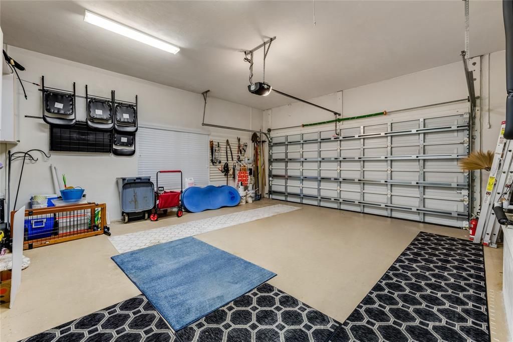 2 car garage with extra cabinets & a work area.