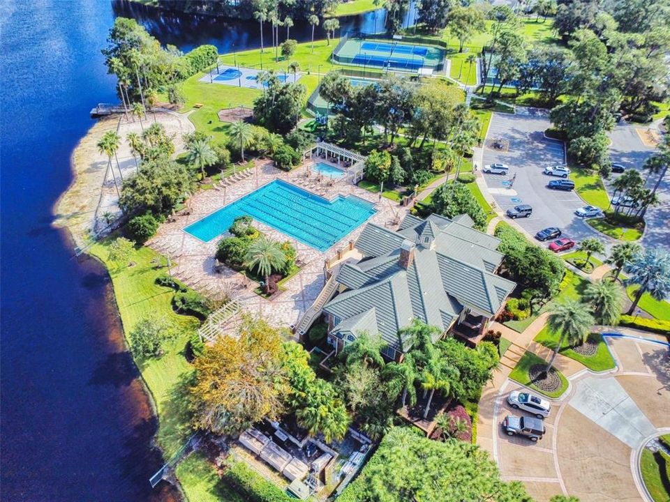 Aeriall view of clubhouse, pool, sandy beach, tennis courts