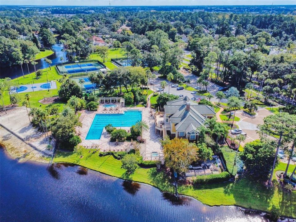 Aerial view of clubhouse, pool, sandy beach, tennis