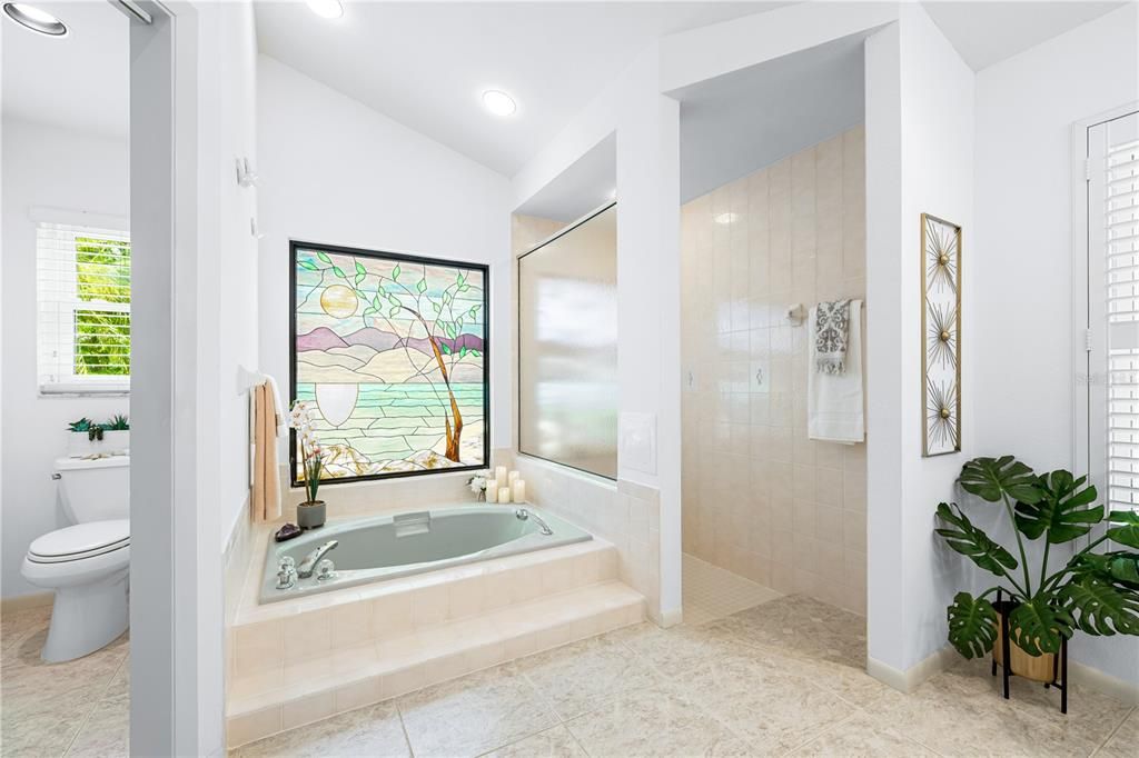 Primary en-suite bathroom featuring Roman shower and garden tub