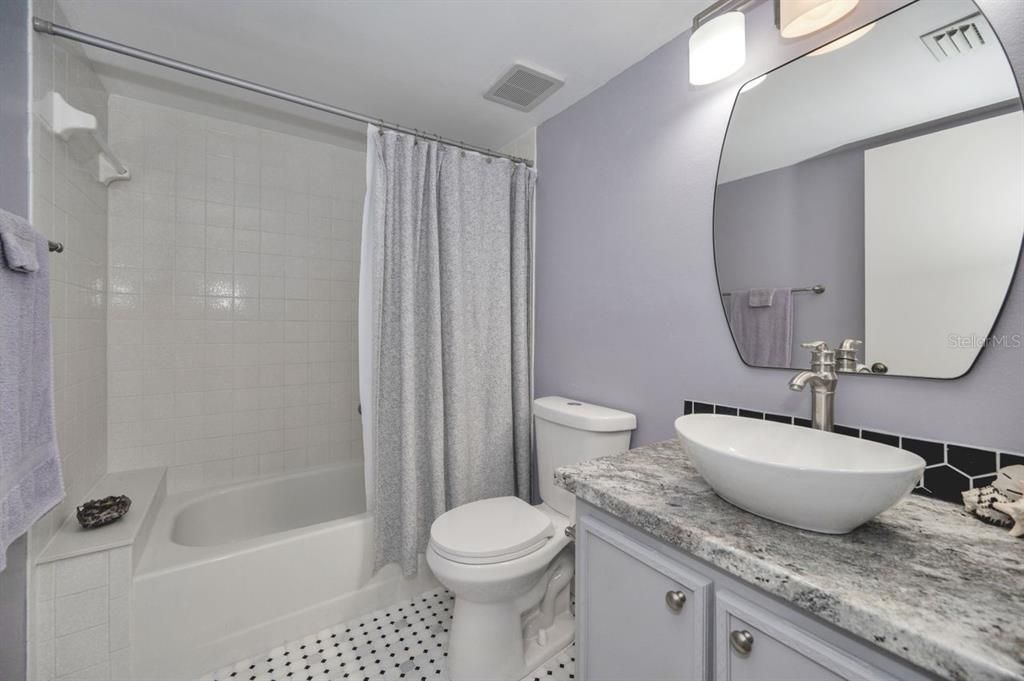 Guest bath has tub and shower combo.