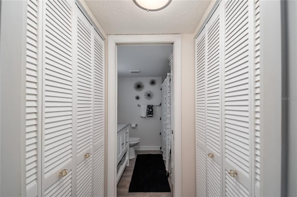 Double closets in hallway separating primary BR & primary BA