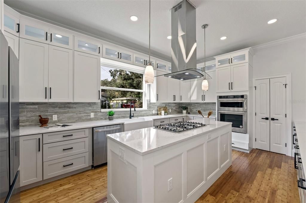 Quartz counters, NATURAL GAS cooktop, solid wood soft close drawers & cabinets, extra deep farmhouse apron sink, walk-in pantry (seen to the right with custom wood shelving) are a few of the highlights of the kitchen. So much work and storage space!