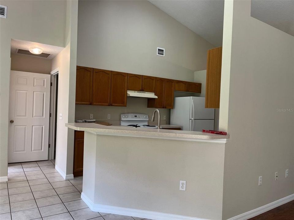 KITCHEN LOOKING INTO HALL TO PRIMARY BEDROOM AND LAUNDRY ROOM TO GARAGE