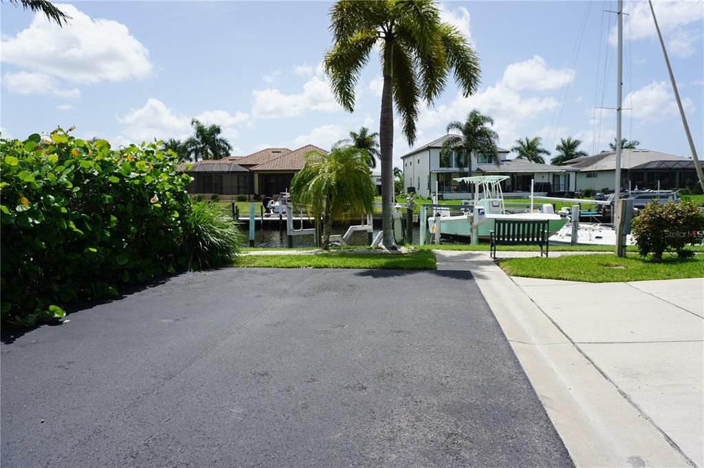 View from driveway to where the boat dock/lift are at end of street