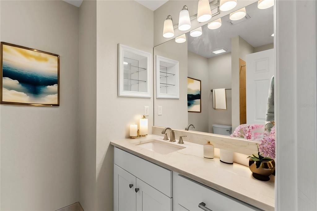 master bath with quartz counter top vanity and virtual staged