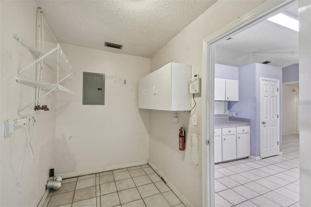 Large indoor laundry room with hookups adjoining the kitchen